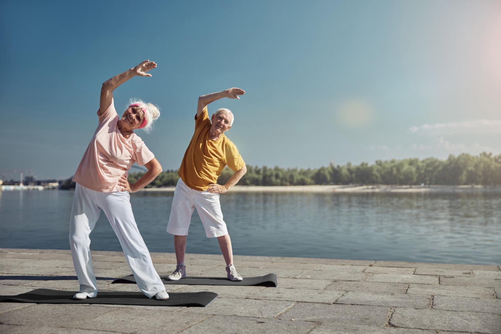 Personas de tercera edad practicando yoga al aire libre