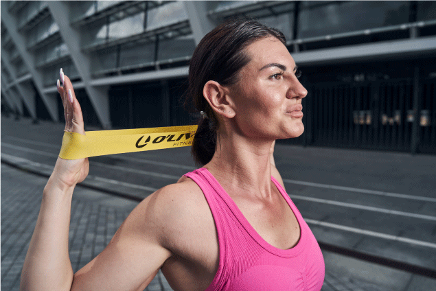 mujer con bandas de resistencia amarilla practicando ejercicios